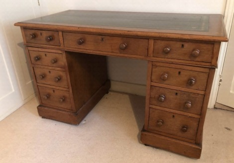 A Victorian oak twin pedestal desk, with inset gilt leather skiver top, three drawers to the frieze pedestal, each with knob handles, plinth base with castors, 75cm high, 122cm wide, 60cm deep.