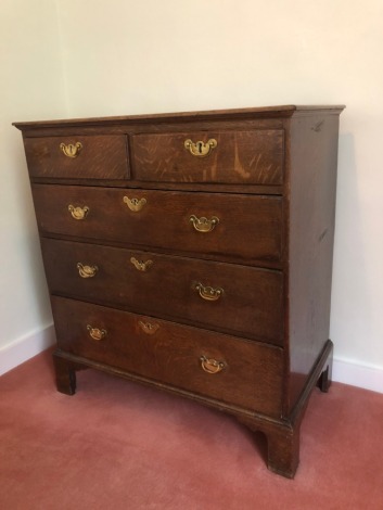 A George III oak chest, of two short and three long graduated drawers, with brass solid back plate handles, and bracket feet, 96cm high, 90cm wide, 50cm deep.