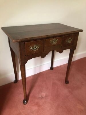 A George III oak lowboy, with over hanging top, three frieze drawers, taper turned legs with club feet, 68cm high, 68cm wide, 40cm deep.