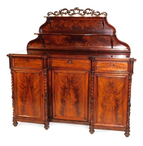 A Victorian flame mahogany inverted breakfront chiffonier, the foliate scroll topped shaped back with two tiered shelves, above three drawers above cupboard doors, flanked by floral carved turned and spiral twist pilasters, raised on fluted feet, 160cm hi