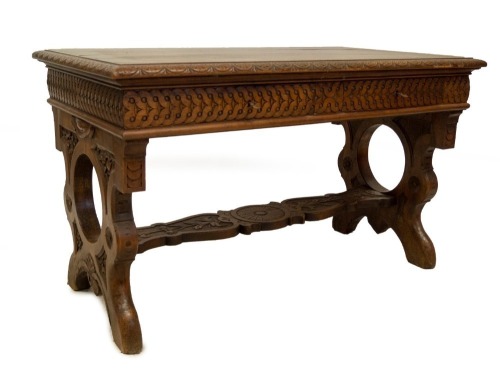 A 19thC Italian walnut centre table, with demi lune carved top, frieze drawers with carved decoration, refectory slab ends and carved stretcher, 78cm high, 129cm wide, 73cm deep.