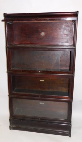 A Globe Wernicke mahogany four section bookcase, the pediment over four glazed up and over doors, raised on a plinth base, 159cm high, 87cm wide, 28cm deep. (AF)