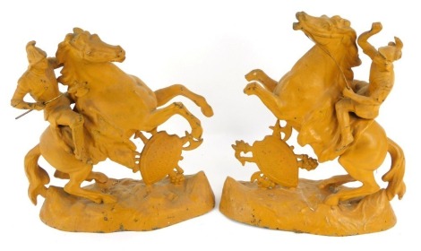 A pair of late 19thC painted spelter figures, modelled as soldiers in armour on rearing horses, supported by a shield and weapons, on a naturalistic base, later painted, 27cm high.