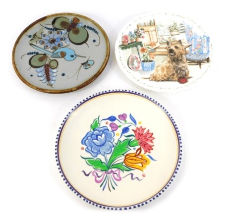 A Poole pottery plate traditionally decorated with flowers, 23cm wide, Royal Albert porcelain plate Mans Best Friend Collection, Playtime, a Cairn Terrier eager for a game, number 3, and a Mexican pottery plate painted with a bird and insects. (3)