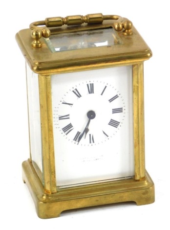 A brass carriage clock, of conventional form, with a white enamel dial beating Roman numerals, single barrel movement, with key, 15cm high.