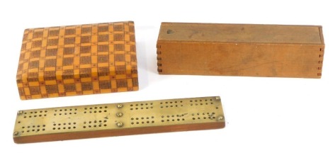 A set of bone and ebony nine button dominoes, boxed, together with a brass topped cribbage board, and a wooden two division card box, containing a set of playing cards. (3)