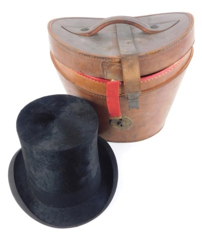 A Dunn and Company black silk top hat, size 40, with a fitted tan leather case.