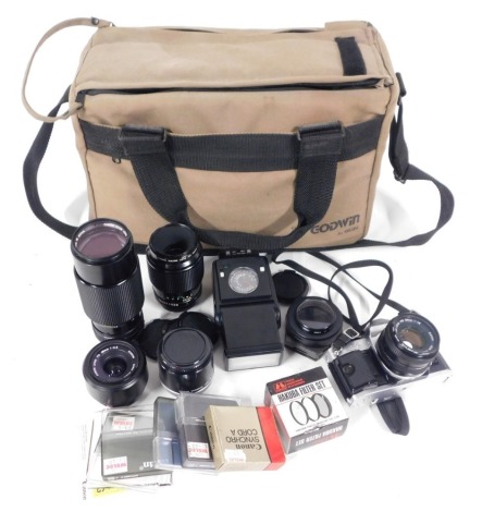 A Canon AE-1 programme camera, with a 50mm skylight lens, zoom lens FD70-210mm, macro lens FD100mm, Speedlite 199A light meter, cased.