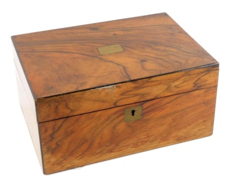 A Victorian walnut sewing box, with brass escutcheons, containing cotton reels, etc., 14.5cm high, 30cm wide, 21cm deep.