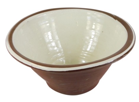 A terracotta and slipware cream bowl, 27cm wide.