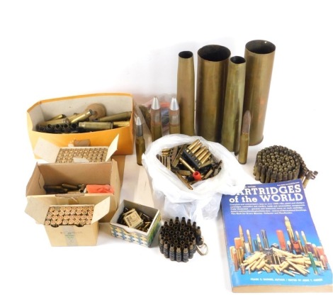 Assorted gun cartridges, shell cases, and a Cartridges of the World catalogue.