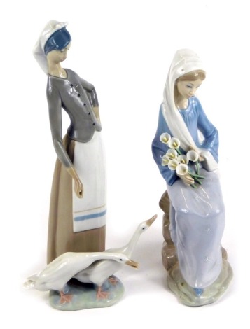 A Lladro porcelain figure of a lady seated holding a clutch of Calla lilies, together with a Lladro porcelain figure of a lady standing with two geese at her feet. (2)