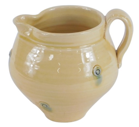 A Fenella Mallalieu studio pottery milk jug, on a yellow ground with detail, bearing partial signature, 11cm high.