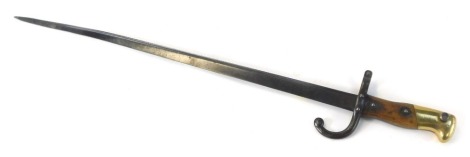 A 19thC French St Etienne bayonet, inscribed Mre D'Armes de St Etienne, Juillet 1879, No PH22471 to handle, with wooden handle, the blade slightly bent, 63cm long.