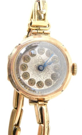 A 9ct gold cased wristwatch, the circular wristwatch head with a silvered dial and blue handles, on expanding gold plated strap, 18.2g all in.