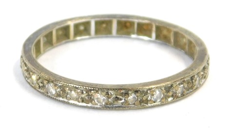 An eternity ring, set with white stones, in a white metal frame, unmarked, ring size Q½, 1.7g all in, boxed.