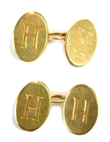 A pair of oval cufflinks, each inscribed H with three chain link, yellow metal stamped 18ct, 11g.