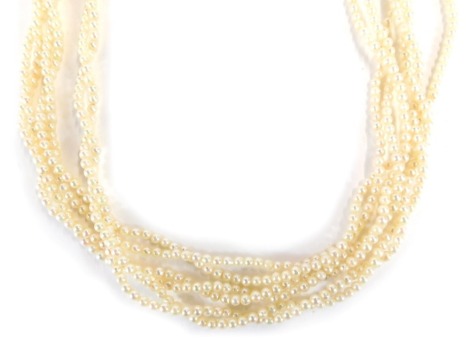 A three double strand cultured pearl necklace, each with small pearl approx 6mm, on knotted spring stand, with a yellow metal clasp marked 9ct, 46cm long.