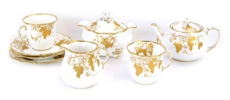 A Hammersley china two place tea service, on a white ground with gilt grape vine decoration, comprising milk jug, cake plate, two cups and saucers, and a teapot.