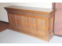 A late Victorian carved oak counter with heavily moulded top and panelled