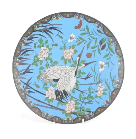 A Meiji period Japanese cloisonne charger, on a blue ground with central storks and flowers, 32cm diameter.