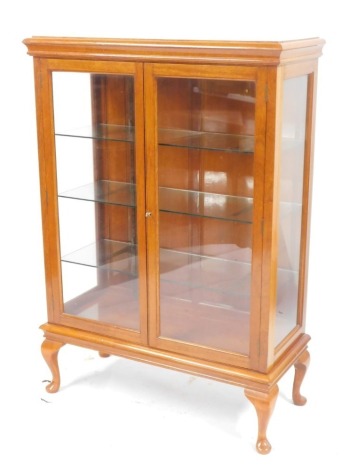 A cherrywood display cabinet by Hawkes & Co of Leicester, with a moulded cornice top above two glazed doors on cabriole legs, 137cm high, 94cm wide, 41cm deep.