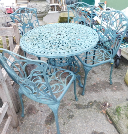 A green cast metal circular garden table and four chairs.