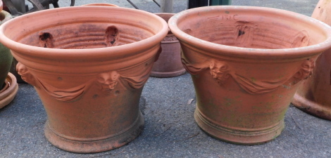 A pair of terracotta garden planters, each with lion mask handle and swags, 38cm high, 50cm diameter.