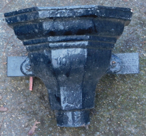 A black painted metal drain hopper.