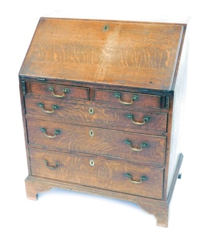 A George II oak bureau, with fall flap resting on lopers, revealing a fitted interior of drawers and pigeon holes, over two short and three long graduated drawers with brass swan neck handles and bracket feet, 96cm high, 77cm wide, 50cm deep..