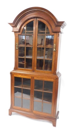 A 20thC mahogany display cabinet, with an arched top, with two glazed panel doors, with glazed panel base and shelves, on bracket feet, 201cm high, 92cm wide, 32cm deep.