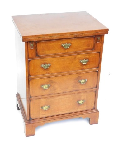 A reproduction walnut hi-fi cabinet, with a record section top above single door with arrangement of shelves, with brass escutcheons on bracket feet, 83cm high, 60cm wide, 43cm deep.