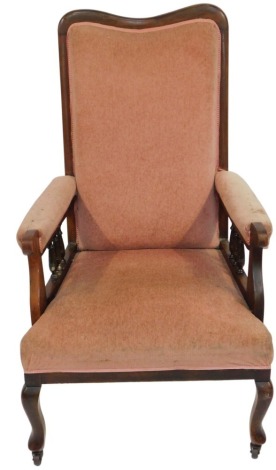 A Victorian spoon back armchair, the shaped and moulded back, with deep seat and pink upholstery, on castors.