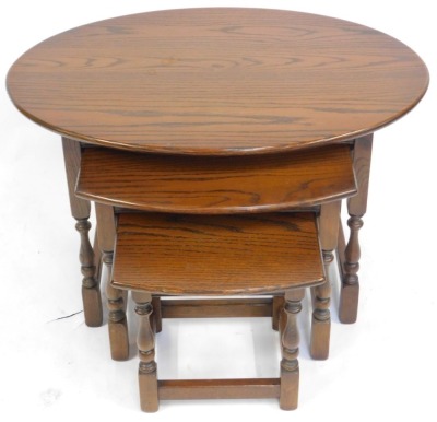 A nest of three Old Charm oak tables, each with an oval top, the largest 53cm high. - 2