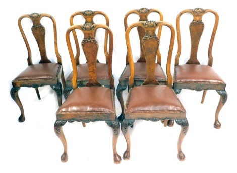 A set of six early 20thC walnut dining chairs, each with a shell carved splat back, with brown leather inset buttoned seats.