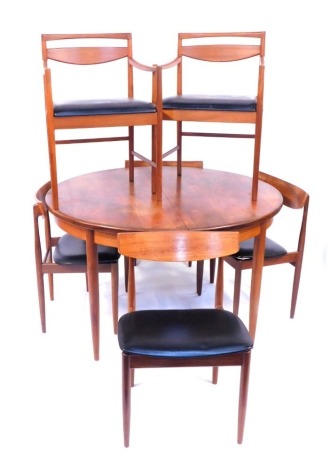 A G-plan teak extending dining table, with one loose leaf on turned legs, 122cm diameter, with a set of two model 9434 McIntosh chairs with arms, and four G-Plan chairs. The upholstery in this lot does not comply with the 1988 (Fire & Fire Furnishing) Re