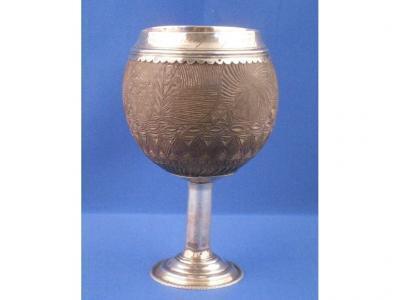 An early 19thC carved coconut cup with white metal mounts