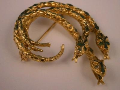 A triple snake brooch in yellow metal