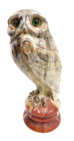 A late 19thC French Emile Galle pottery figure of an owl, with green glass eyes, and mottled feathers, on a socle, signed beneath, 35cm high.