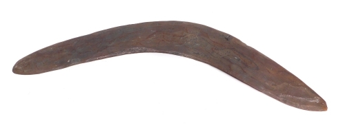 An early 20thC Australian boomerang, carved with a textured snake to both sides, 55cm long.