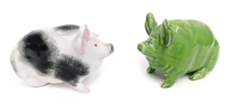 A late 19thC Wemyss pottery pig, in green glazes, impressed marks beneath, 12cm high, and another in black and white. (2 AF)