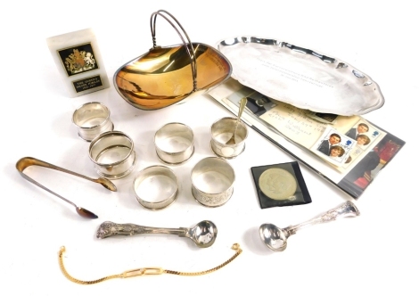 A 1950s white metal basket, marked Dem Siegerpaar, 925, various silver and other napkin rings, silver plated tray, sugar bows, Queen's Silver Jubilee crown plaque, Royal Commemorative stamps, etc., 2oz of silver. (a quantity)