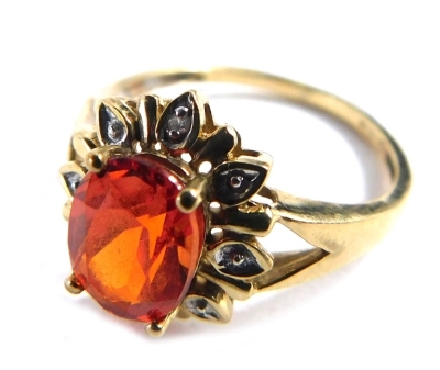 A 9ct gold topaz and diamond floral cluster ring, with central oval orange topaz, surrounded by tiny diamonds, on V splayed shoulders, ring size M, 2.1g all in.