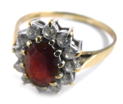 A 9ct gold cluster ring, with central garnet surrounded by cz stones, in a raised basket, ring size M½, 1.8g all in.