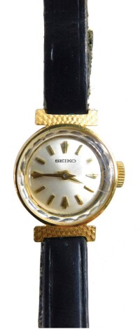 A Seiko 9ct gold cased wristwatch, with small silver coloured dial, serial number 4500603, on a leather bracelet, 4cm diameter, 8.2g all in.