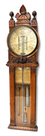 An early 20thC Admiral Fitzroy oak cased improved barometer, with 25cm diameter main dial, mercury column and thermometer, in heavily carved case, with adjusting knop surmounted by acanthus leaf and orb finials, 117cm high.