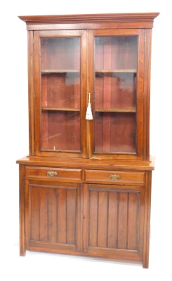 A late Victorian walnut bookcase, with fixed cornice above two shelves, the subsection with two frieze drawers above double cupboard, on block stiles, 111cm high, 121cm wide, 45cm deep.