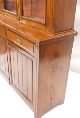 A late Victorian walnut bookcase, with fixed cornice above two shelves, the subsection with two frieze drawers above double cupboard, on block stiles, 111cm high, 121cm wide, 45cm deep. - 2