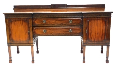 An Edwardian mahogany inverted breakfront sideboard, with a raised back, the top with a moulded edge above a blind fret carved frieze, with two drawers flanked by two panelled doors on square tapering legs, 184cm wide.