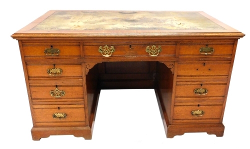 An early 20thC oak twin pedestal desk, with tooled leather top above three frieze and six pedestal drawers, on bracket feet, 78cm high, 137cm wide, 84cm deep.